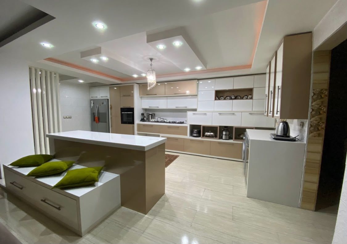 Large open-plan kitchen by the MALCON team with white gloss and wood-finish cabinetry, an island and feature ceiling lighting