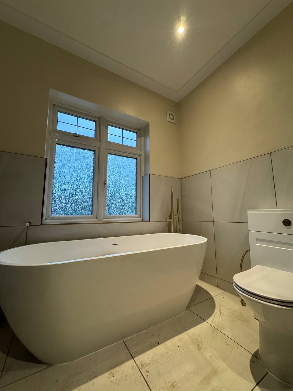 Bathroom with freestanding bath and brass tap, renovated by MALCON