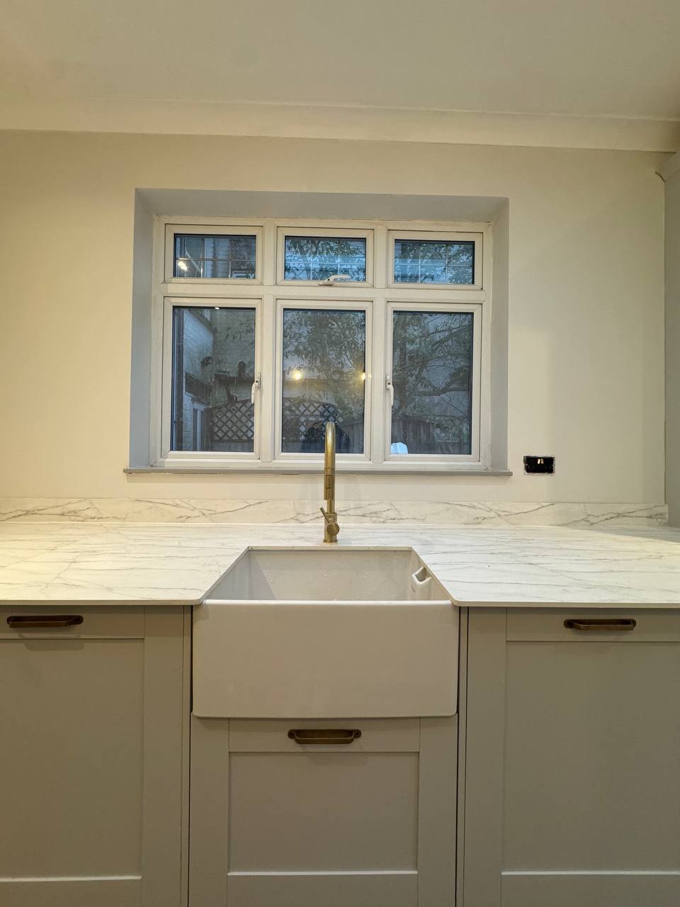 Belfast sink with brass tap in a Shaker-style kitchen by MALCON