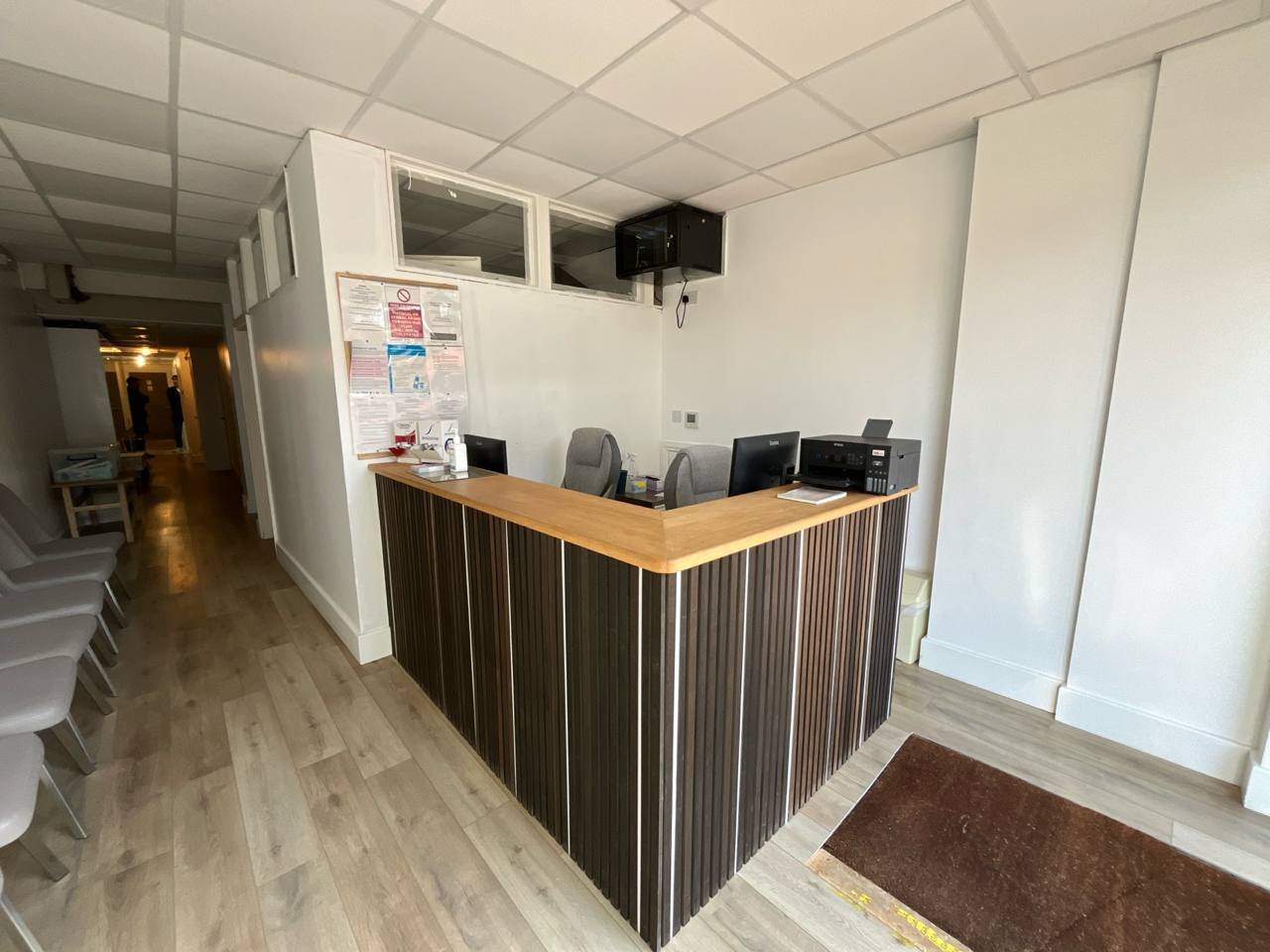 Bespoke reception desk with dark ribbed front and timber top, made and fitted by MALCON